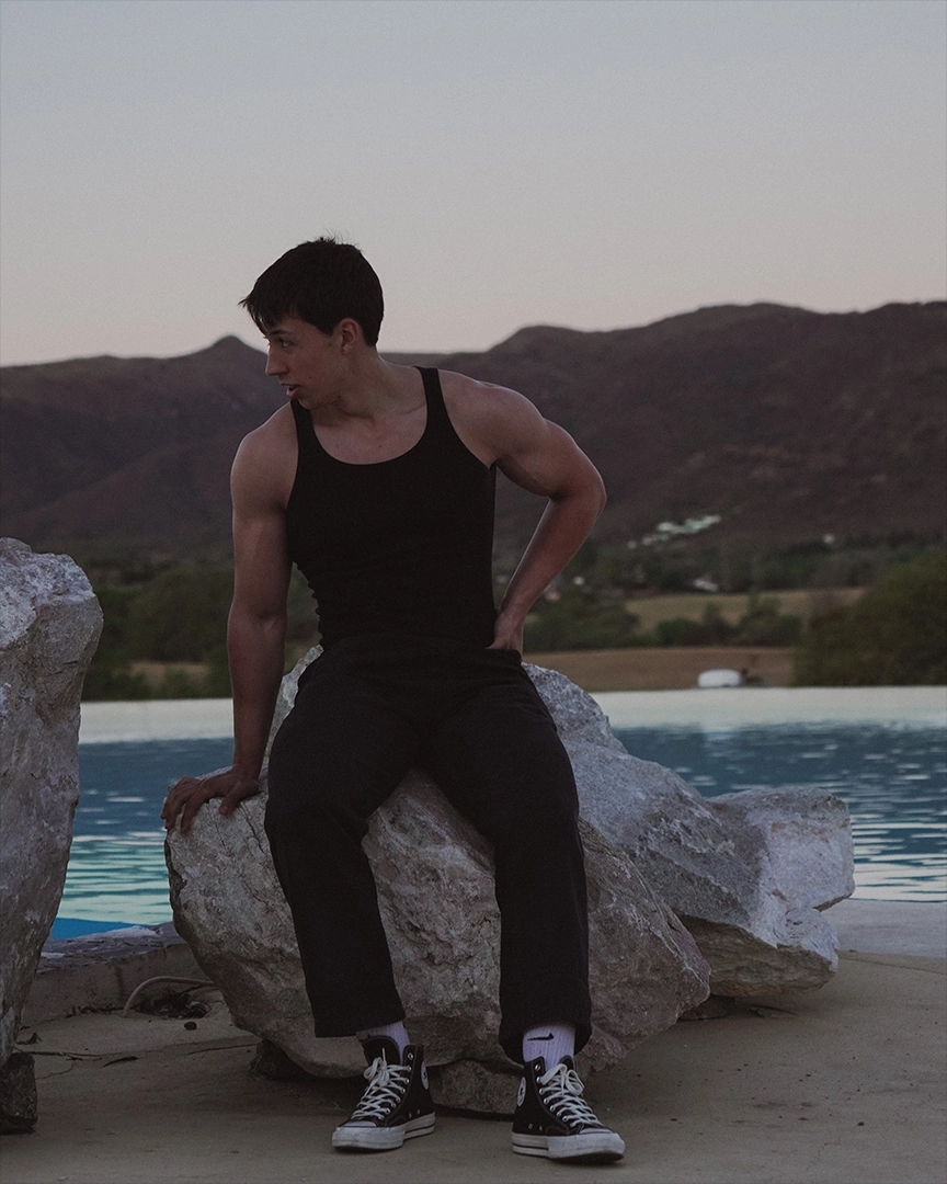 teo sit on a rock and looking away